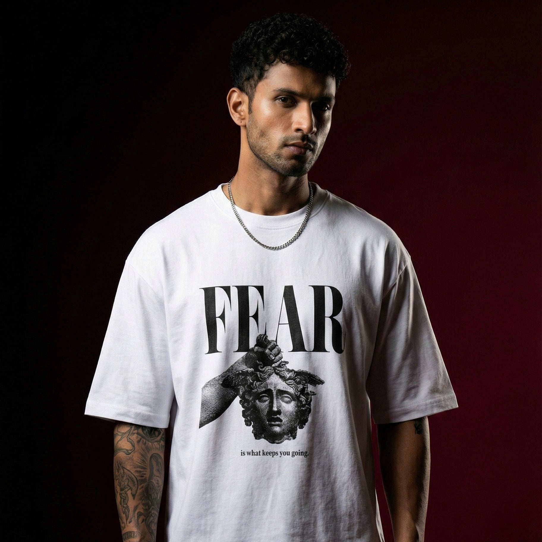 Person wearing a white t-shirt with 'FEAR' graphic design on a dark background
